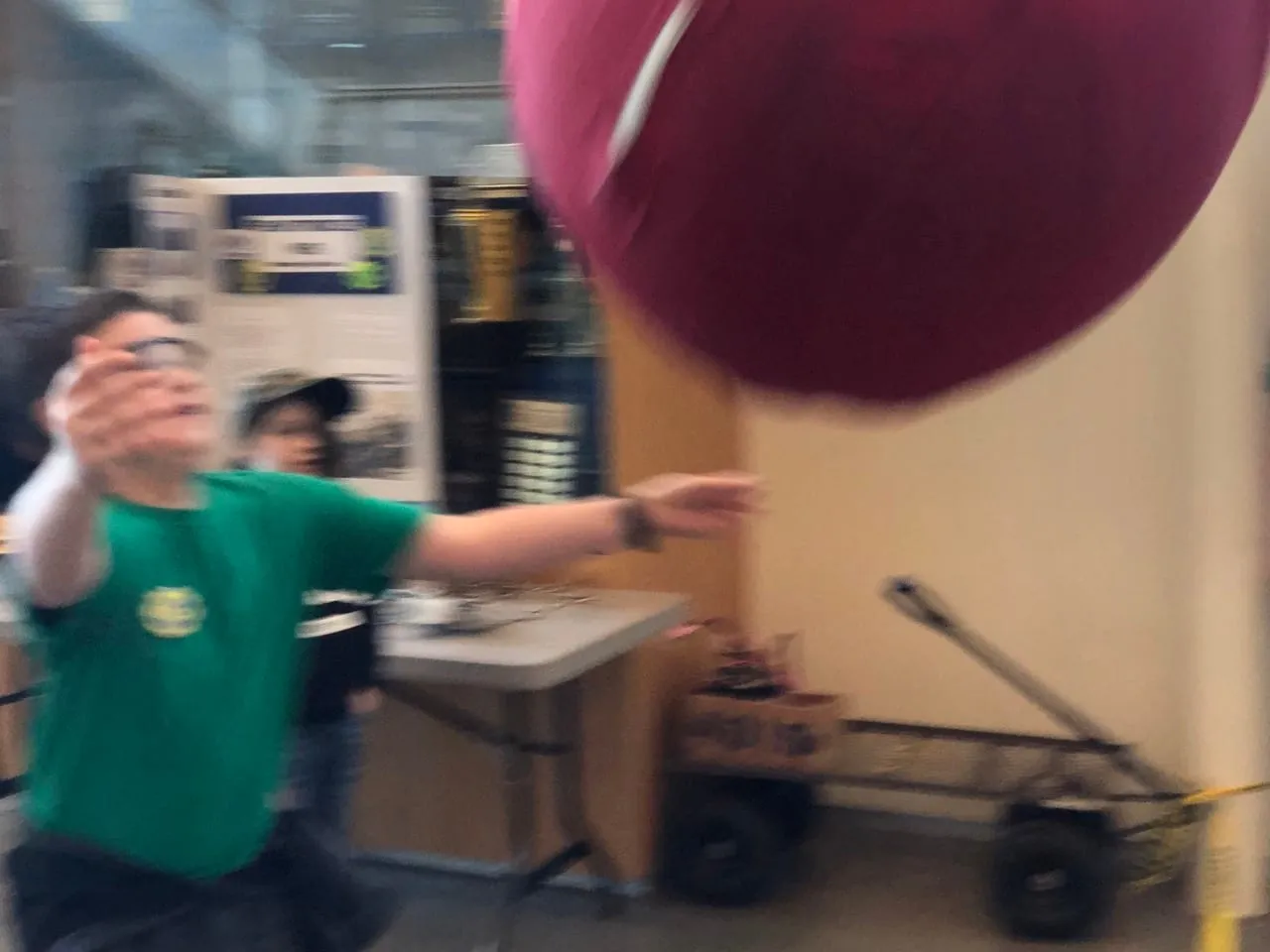 A young student launches the ball with ATLaS as another student catches it!